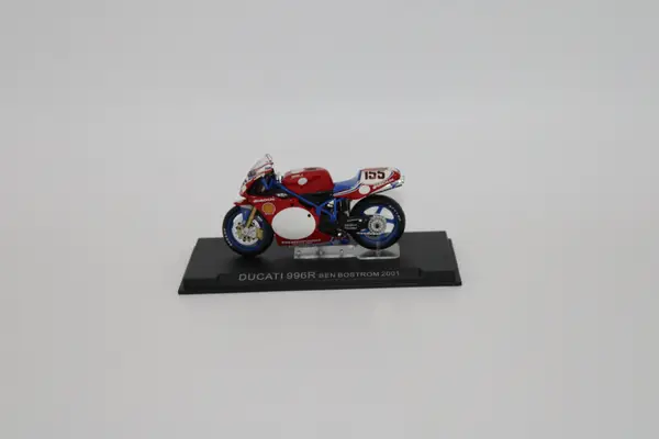 Deagostini red, blue and white Ducati No. 155 Ben Bostrom diecast motorcycle model on a stand.
